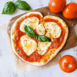 Pinsa mit Tomate Mozzarella – einfach, lecker und erstaunlich gut 2 pinsa mit tomate mozzarella serviert auf schneidebrett mit basilikum