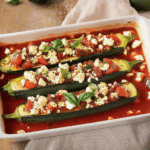 Gefüllte Zucchini mit Feta und Tomaten – einfach, lecker & gesund 4 Gefüllte Zucchini mit Feta und Tomaten in schräger Ansicht mit drei Hälften
