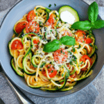 schnelle pasta mit zucchini und tomaten als close-up mit parmesan und basilikum