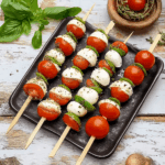 Tomate Mozzarella Spieße mit Balsamico: einfach, kreativ & unwiderstehlich 6 Tomate Mozzarella Spieße mit Balsamico auf rustikaler Holzplatte mit Kräutern